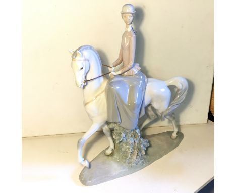 A large Lladro figure of a lady riding a horse 440 mm 