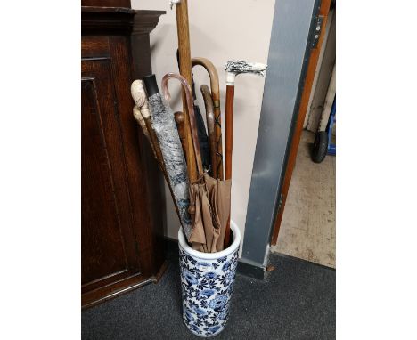 A blue and white stick pot, sticks, umbrella etc 