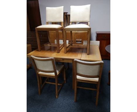 A light oak flap sided dining table together with six cream studded leather chairs 