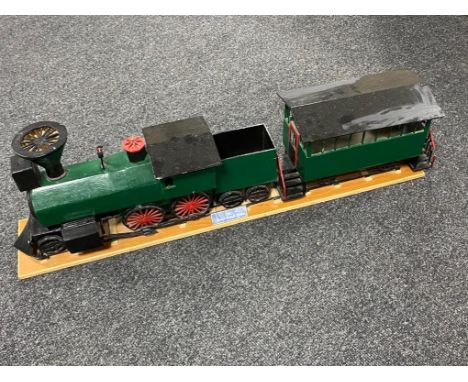 A hand built wooden model of a steam train with carriage
