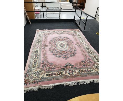 A pink fringed Chinese carpet, 370cm by 275cm