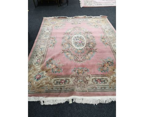 A Chinese pink fringed carpet, 316cm by 245cm