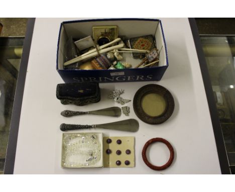 A shoe box containing a pin cushion box; two silver handled shoe horns; a pair of glove stretchers; a cinnabar bangle etc.