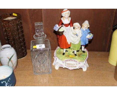 A glass decanter and stopper; and a Yardley's figure group 