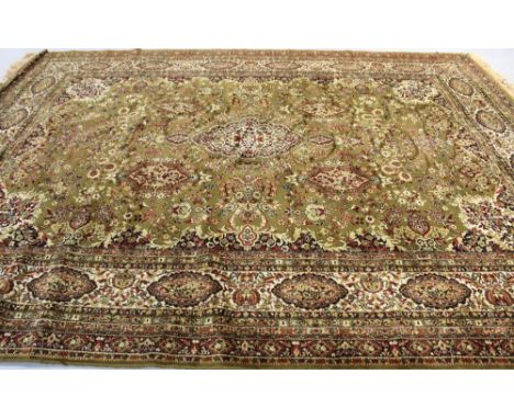A large green ground Tabriz-style carpet within a scrolling foliate multi-border, width 124cm..