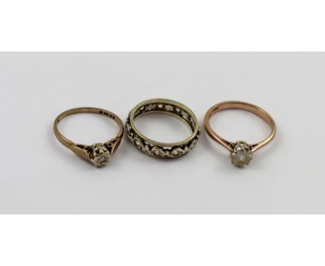 Three 9ct gold rings, a full eternity ring set with small white stones, size L, a solitaire illusion-set diamond ring, size M