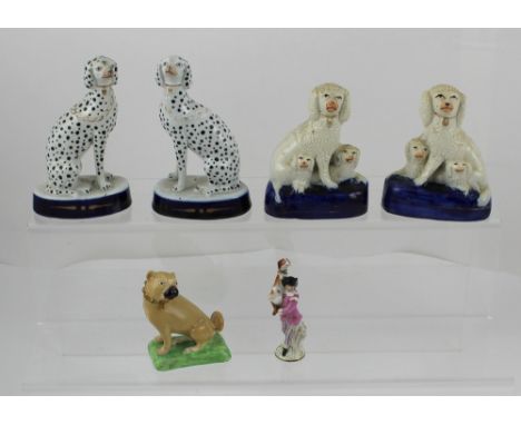 Two pairs of 19th century Staffordshire dogs, a pair of Dalmatians on a raised cobalt blue base and a pair of poodles with pu