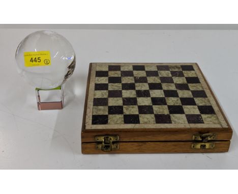 A rotating glass globe, and a carved stone chess set with a stone inset board Location: 