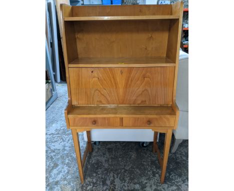 A light wood bureau, open shelves above a fall flap revealing a fitted interior, over two drawers, on tapering legs united by