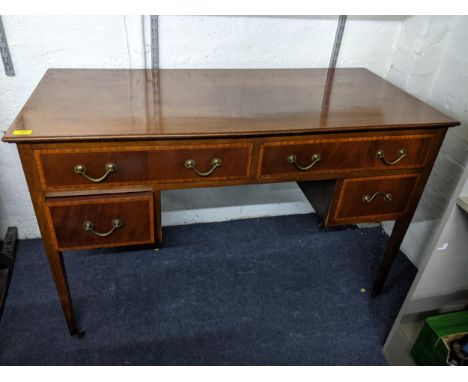 A 1930's oak cabinet with twin carved panelled doors, over a shelf and an Edwardian mahogany kneehole desk (Leg broken)Locati