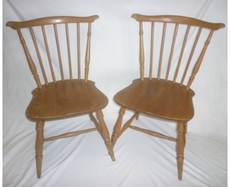 A set of four 1960's Ercol light elm spindle-back dining chairs with curved backs and plain seats