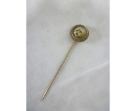 A 19th Century gilt stick pin with ceramic centre depicting a portrait of a dog