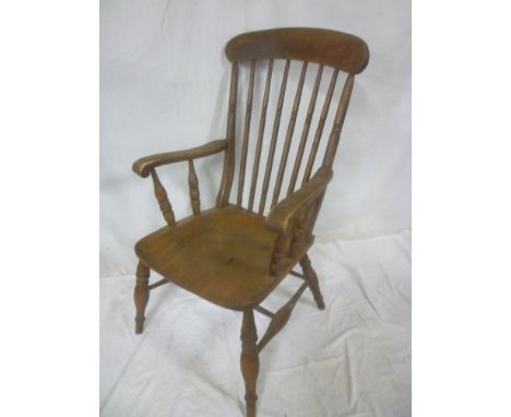 A Victorian beech &amp; elm spindle back kitchen carver chair with shaped seat on turned tapered legs