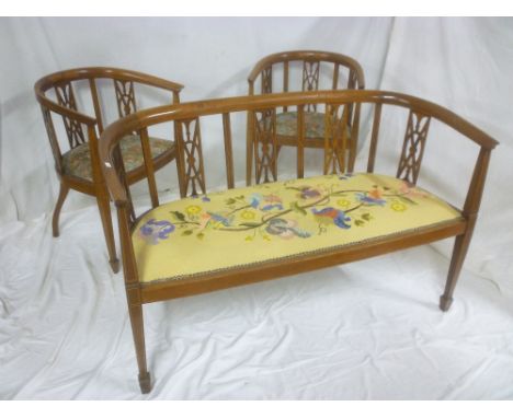 An Edwardian inlaid mahogany three piece parlour suite comprising two seat settee with pierced panel backs and upholstered se