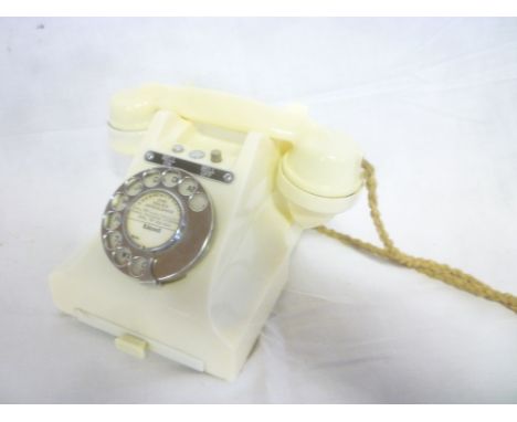A vintage white plastic telephone with chromium plated mounts
