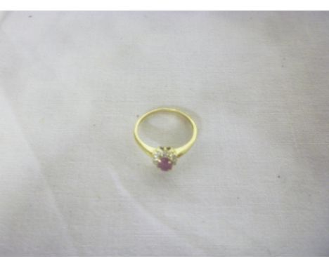 A 9ct gold dress ring set a central ruby surrounded by diamond chips