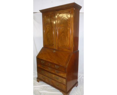 An early to mid 19th Century mahogany bureau/bookcase with numerous pigeon holes and drawers enclosed by a fall front above f
