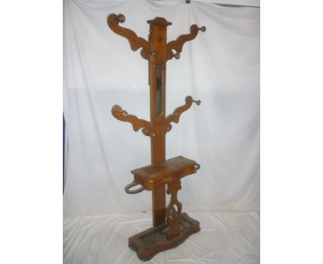 A Victorian mahogany hall tree with central mirror panel and compartment enclosed by a hinged cover