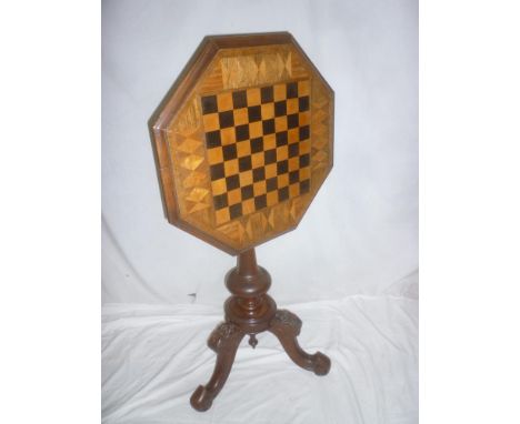 A Victorian inlaid mahogany octagonal tilt top games table with in-set chessboard top on turn column with carved tripod base