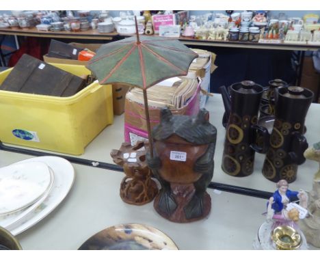 A CARVED WOOD LARGE TOAD ORNAMENT WITH AN UMBRELLA AND A CARVED TREE TRUNK PATTERN CANDLESTICK (2) 