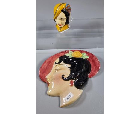 Art Deco ceramic wall plaque/mask of a lady with hat, together with another Art Deco ceramic lady mask with ring handle. (B.P