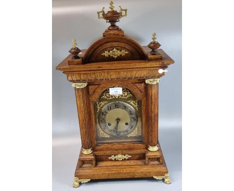 Early 20th Century oak architectural two train mantel clock with urn finial, gilded and gold finish face, with gilded claw fe