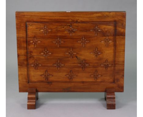 A teak firescreen with all-over carved floral decoration, &amp; on shaped feet, 36¼” wide x 31¾” high. 