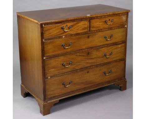 A Georgian mahogany chest fitted two short &amp; three long graduated drawers with brass swing handles, &amp; on bracket feet