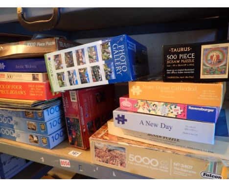 Shelf of jigsaw puzzles by Falcon Waddingtons and others from 1000 to 5000 pieces New York skyline London Bridge etc 