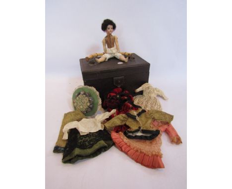 A small bisque head doll with a trunk of clothes 