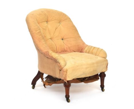 A shapely Victorian button back armchair, in need of reupholstery, on turned front legs and brass casters, 63cm wide 