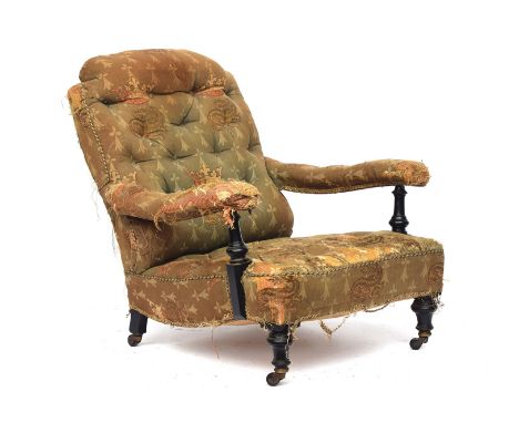 A 19th century armchair in the manner of Howard &amp; Sons, in need of reupholstery, button back, the open arms with ebonised