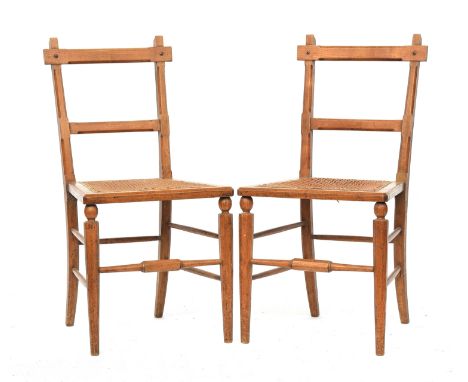 A pair of light oak and caned side chairs in the manner of James Shoolbred, the octagonal faceted front legs joined by periph