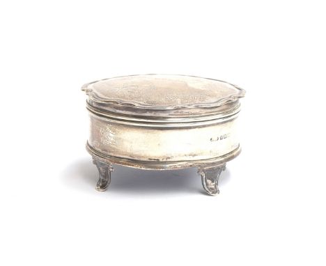 A George V circular silver trinket pot, Birmingham 1921, hinged cover with engraved ribbon decoration, shaped edge, on four f