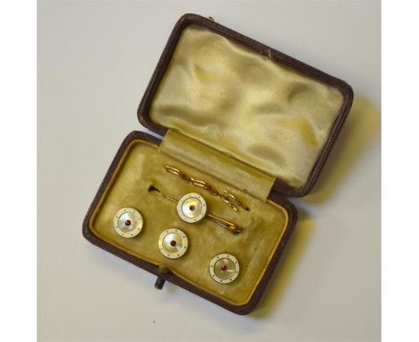 A cased set of mother of pearl and white enamel dress studs and pin, the centre set with small ruby, yellow metal set stamped