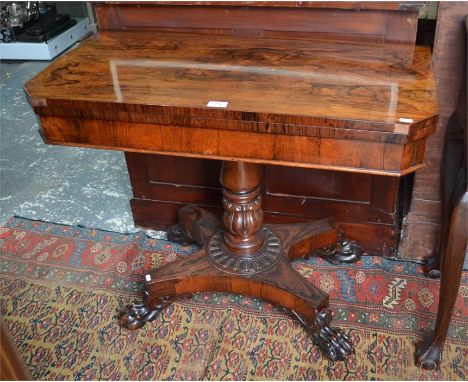 A mid 19th century rosewood card table, the fold-over top with canted corners enclosing a green baize interior, raised on an 