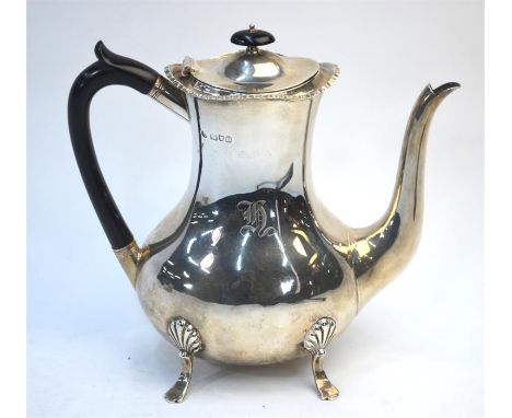 An Edwardian heavy quality oval pear-shaped coffee pot on four pad feet with ebony handle and silver mounted infuser-net inse