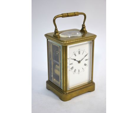 A French brass carriage clock with enamel dial, striking on a coiled gong, 17 cm high overall (inc handle)