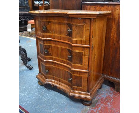 An antique Italian cross-banded fruitwood commode chest of three drawers, of inverted serpentine form raised on ball feet, 70