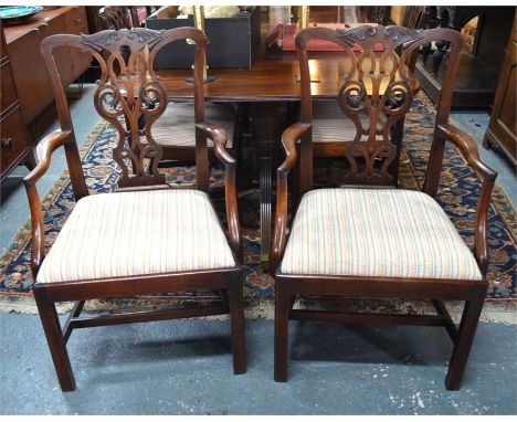 A set of eight Chippendale style mahogany dining chairs, with moulded and pirerced vetical splats over drop-in seat pads, rai