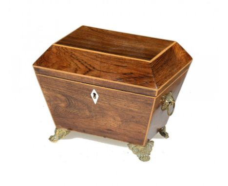 A REGENCY ROSEWOOD AND LINE INLAID TEA CADDY, C1820  sarcophagus shaped, the fitted interior retaining a pair of covers, bras