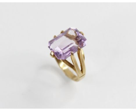 An amethyst set 9ct gold dress ring, the central rectangular mixed cut stone with canted corners, (measuring 14mm x 10mm), cl