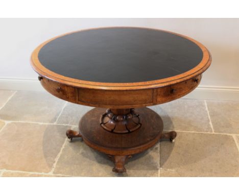 A mid 19th century golden oak library drum table, the moulded circular top with an inset skiver, above four opposing frieze d