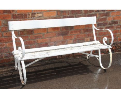 A 19th century painted iron and hardwood bench, the pair of scrolling strapwork supports united by a serpentine hardwood back