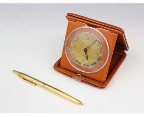 A yellow metal ballpoint pen, stamped '18kt', 12.6cm long, together with a Doxa 8 Day travelling clock set to a leather case,