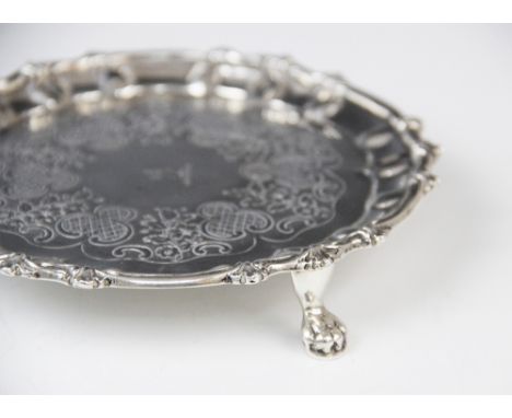 A George III Irish silver waiter, possibly by Thomas Townsend, of circular form with scalloped border raised on three paw fee