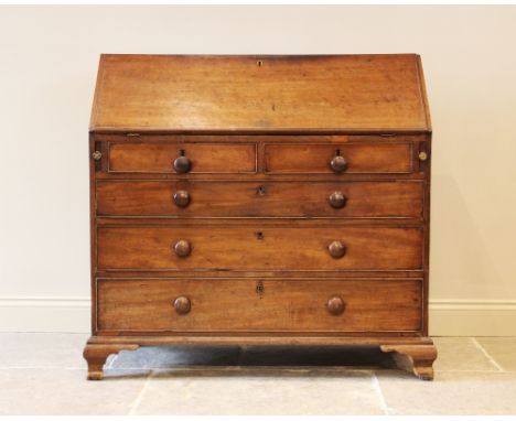 A George III mahogany bureau, the fall front opening to a compartmentalised interior, over two short and three long graduated