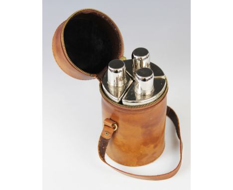 A mid 20th century three-piece glass and white metal hunting flask set, each of faceted form with plain polished white metal 