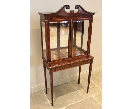 An Edwardian Sheraton revival mahogany display cabinet, by 'Old Time Furnishing Co, Westminster', the twin swan neck pediment