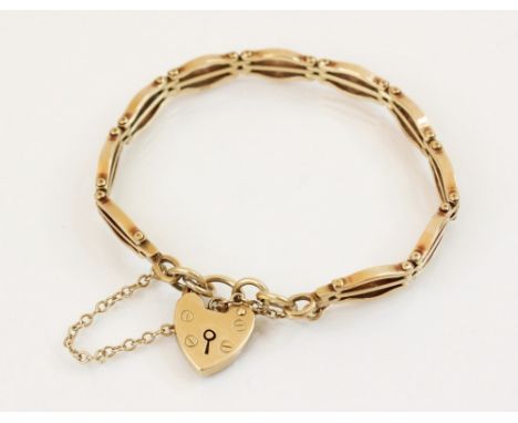 A 9ct gold gate link bracelet, 18cm long, suspending a 9ct gold heart-shaped padlock fastener, 14mm x 19mm, marks for Birming